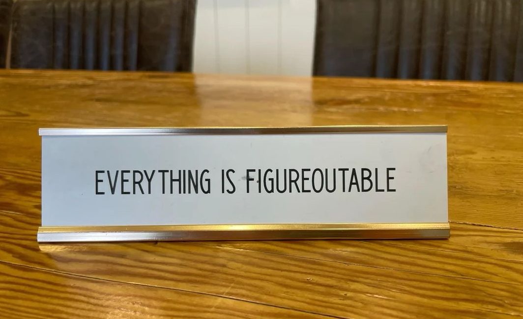 Desk nameplate reading Everything is Figureoutable